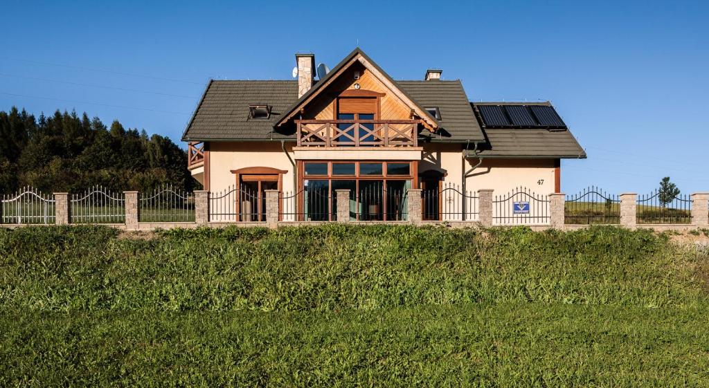 a house on top of a hill with a fence at Dom Na Stoku - Hillside Cottage Eliza in Szczawnica