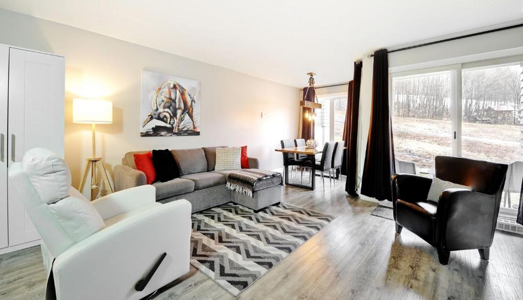 a living room with a couch and a table at Hameau 28-41 studio in Stoneham
