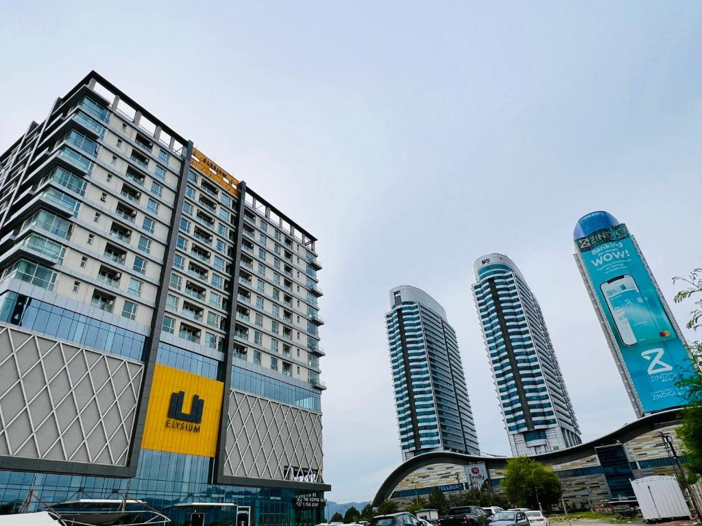 two tall buildings with cars parked in front of them at Elysium Tower Luxury Studio & One Bedroom Apartments Opposite Centaurus Mall Islamabad in Islamabad
