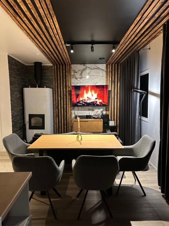 a dining room with a table and a fireplace at Arctic Glow Apartment 3 in Ivalo