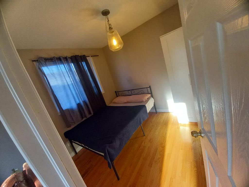 a small room with a bed and a window at Central Location New Year Stay- Free Parking & Fast Wifi in Kitchener