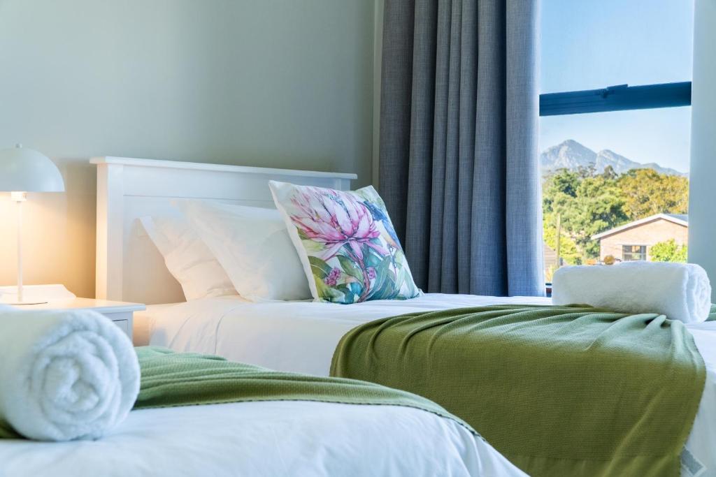 two beds in a room with a window at Amara Mountain View George in George