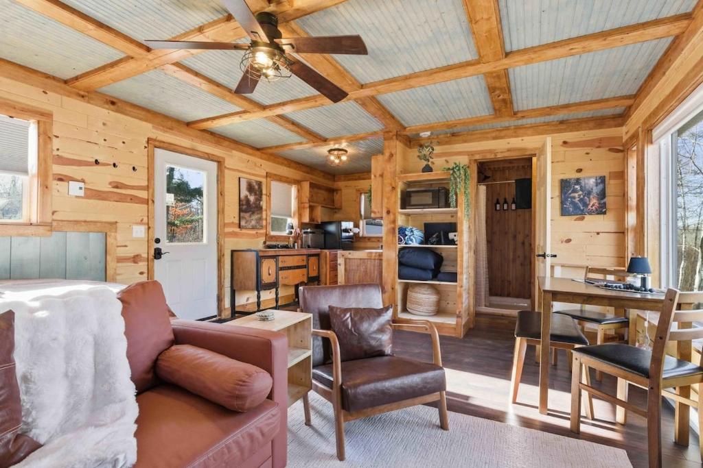 a living room with a couch and a table at NEW! BEAR Necessities tiny home, outdoor theater! in Garrison