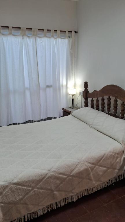 a bedroom with a large bed and a window at Casa Julia in Puerto Madryn
