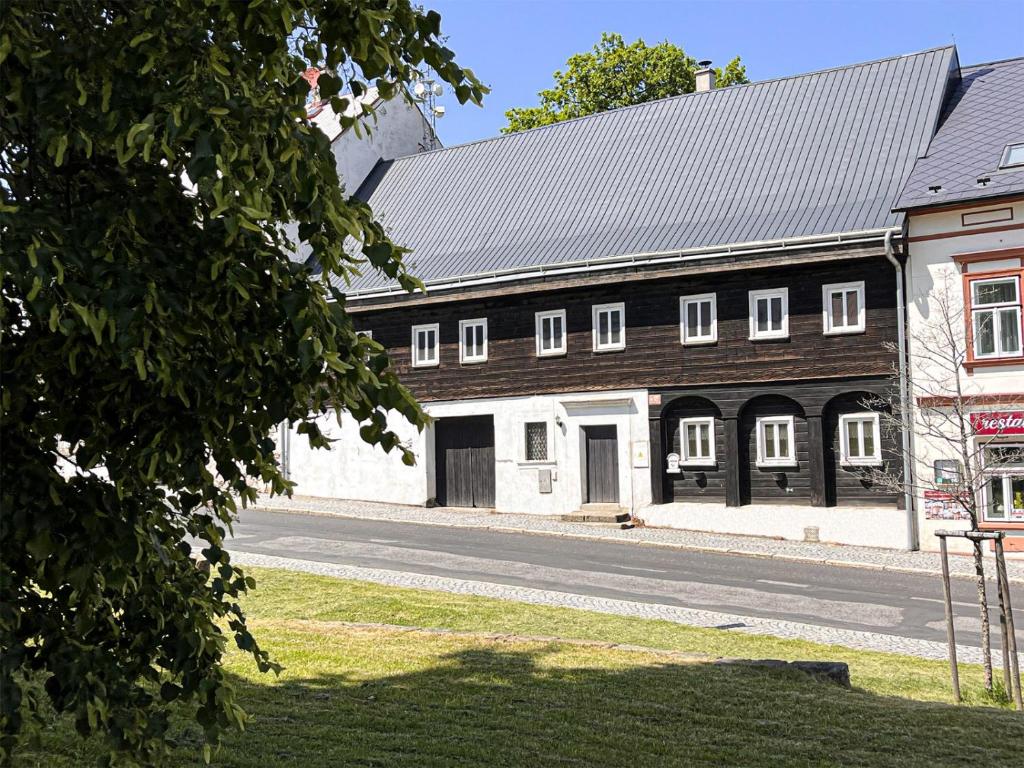 a large black and white building with a garage at Chalupa Domovina in Jiřetín pod Jedlovou