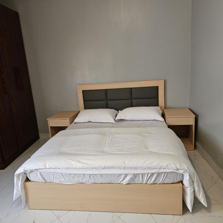 a bed in a room with two nightstands and a bed sidx sidx sidx at SBJ's Home in Entebbe