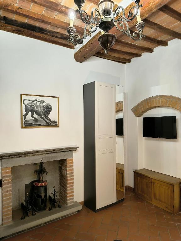 a living room with a fireplace and a chandelier at La casa di Fannie in Arezzo