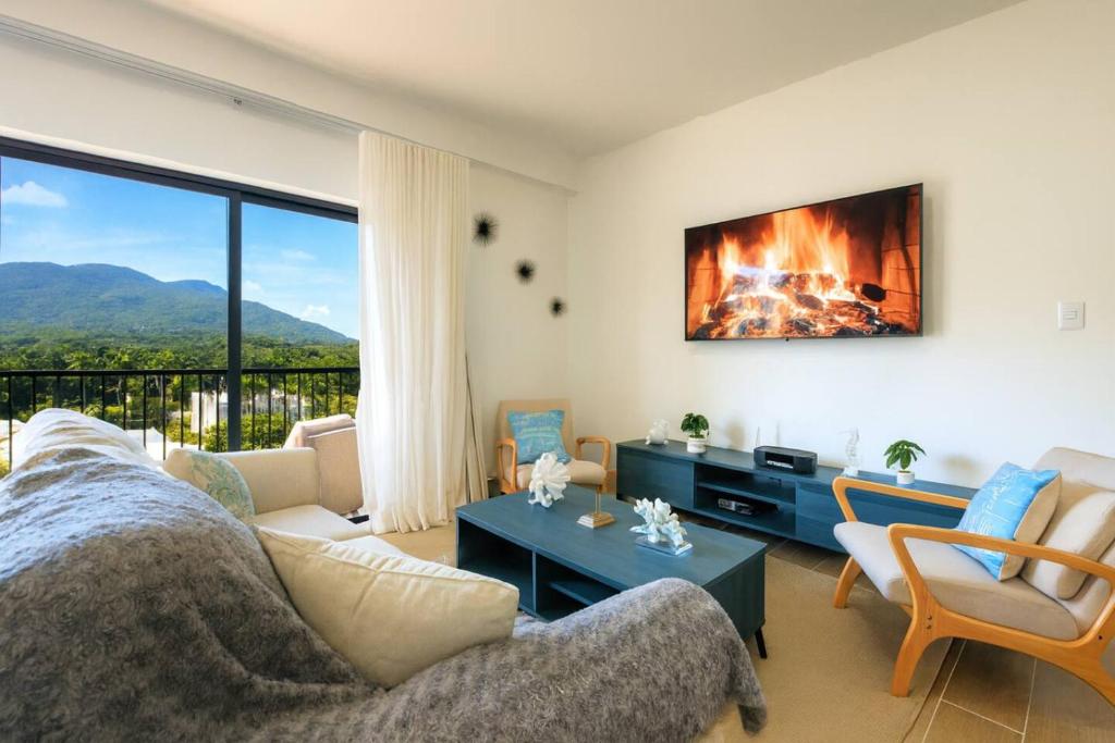 a living room with a couch and a fireplace at Cozy 2BD Condo, Near Beach in San Felipe de Puerto Plata