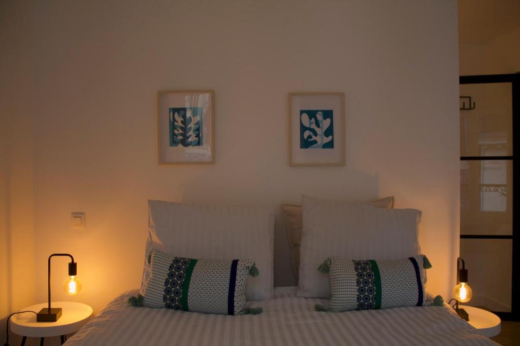 Un dormitorio con una cama con dos lámparas encima. en Cozy Central Apartment with Cathedral View on the 3rd floor, en Amberes