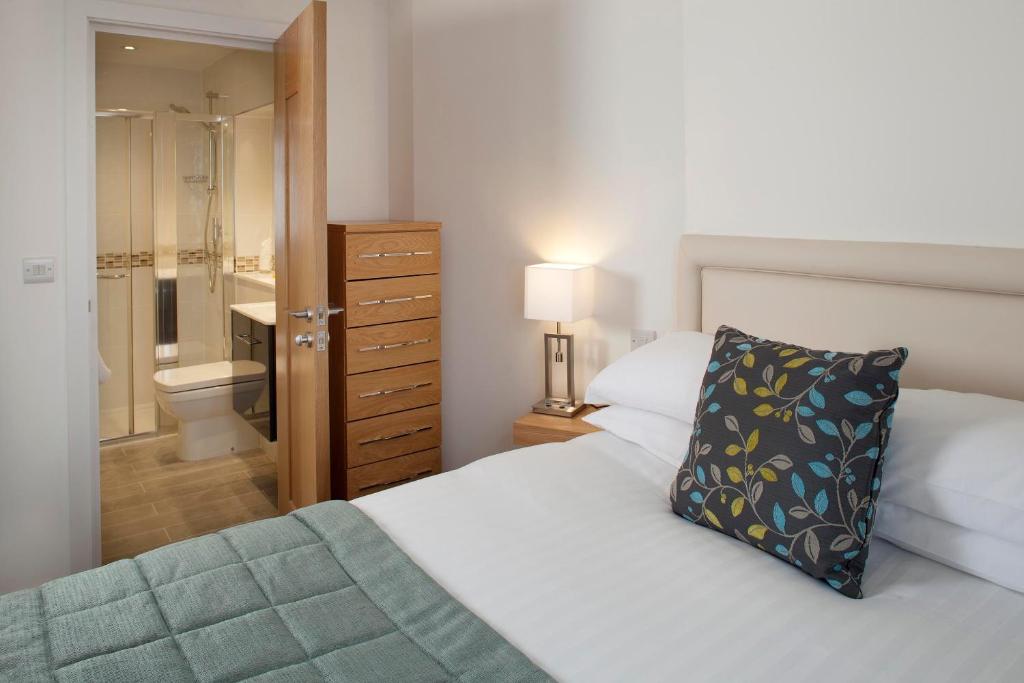 a bedroom with a bed and a bathroom with a toilet at Falmouth Self Catering Lodges in Falmouth
