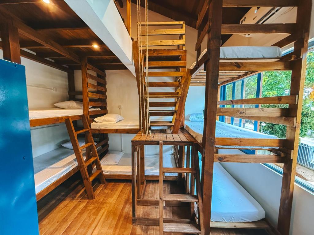Cette chambre dispose de plusieurs lits superposés et d'une échelle. dans l'établissement Sea Wolf Surf Hostel Campeche, à Florianópolis