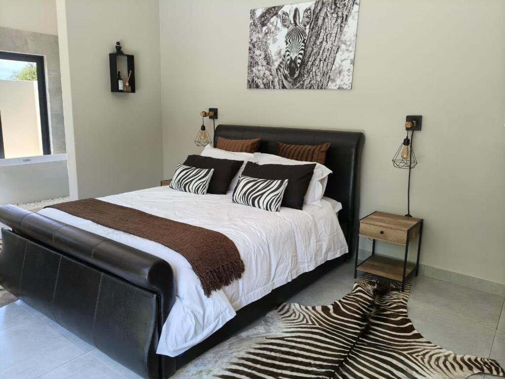 Eagle's Retreat في مارلوث بارك: غرفة نوم بسرير كبير وسجادة حمار وحشري