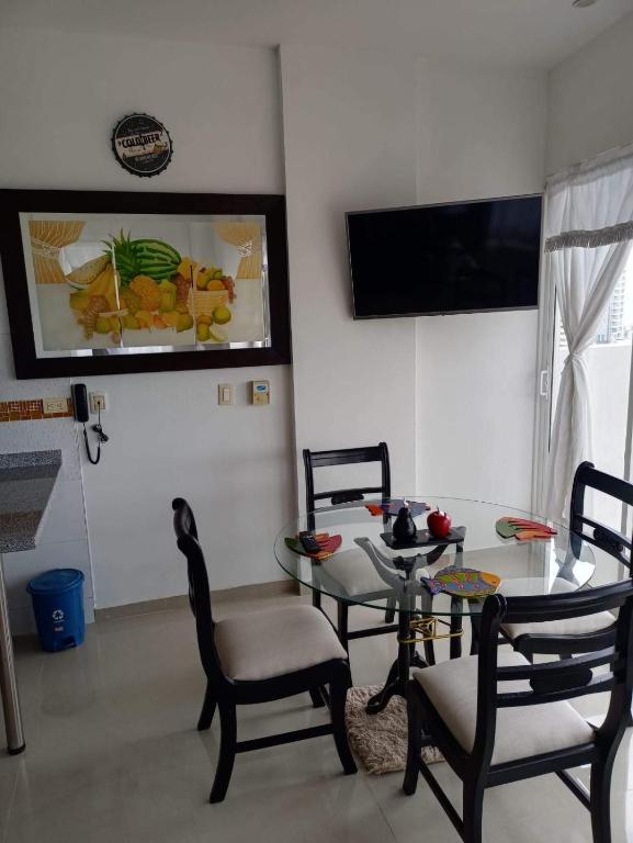 a living room with a table and chairs and a television at SantaMartaTerrace in Santa Marta