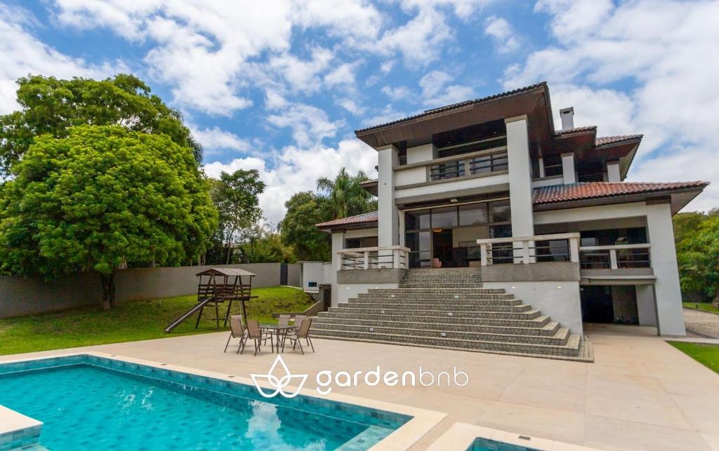 een huis met een zwembad ervoor bij Refúgio de Luxo à beira do Lago Passaúna, in Ferraria