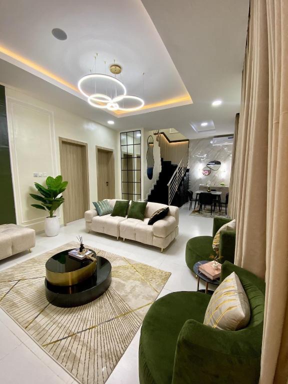 a large living room with a couch and a table at Bomo Apartment in Ikota