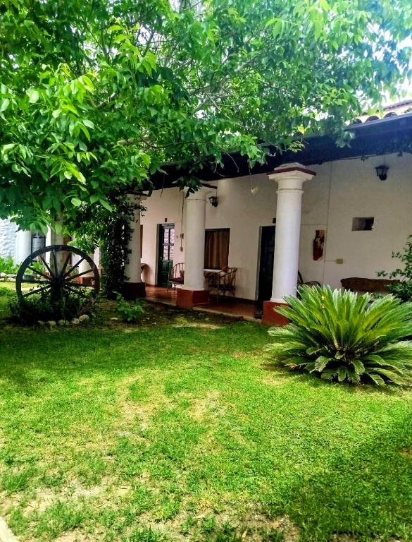 a house with a green yard with a house at Hostal Lo de Peñalba in Cafayate