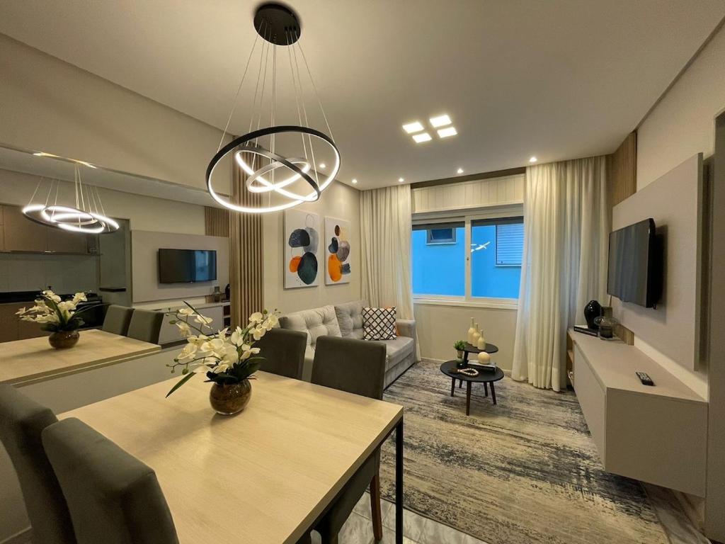 a living room with a dining table and a living room with a couch at Apartamento na praia in Capão da Canoa