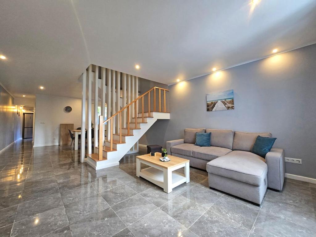 een woonkamer met een bank en een trap bij Casa da Maré Azul in São Roque