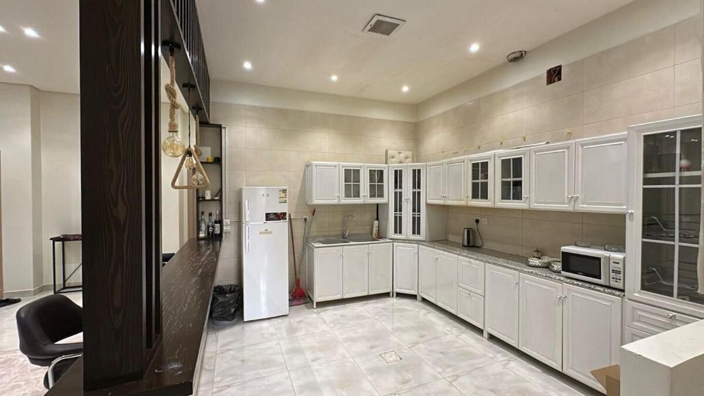 リヤドにあるشقة الفخامة - مدخل خاص ودخول ذاتيの白いキャビネットと白い冷蔵庫のあるキッチン