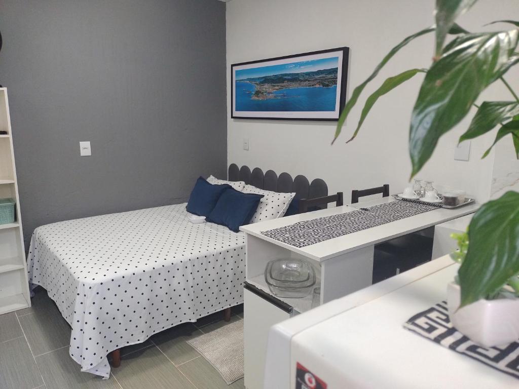 Zimmer mit 2 Betten und einem Tisch mit einer Pflanze in der Unterkunft Studio Beira Mar in Imbituba