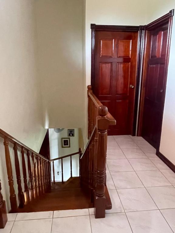 a hallway with a wooden door and a staircase at A taste of M&M in Belize City