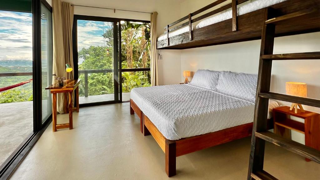 a bedroom with a bunk bed and a balcony at Searenity Octopus Cottage in Port Antonio