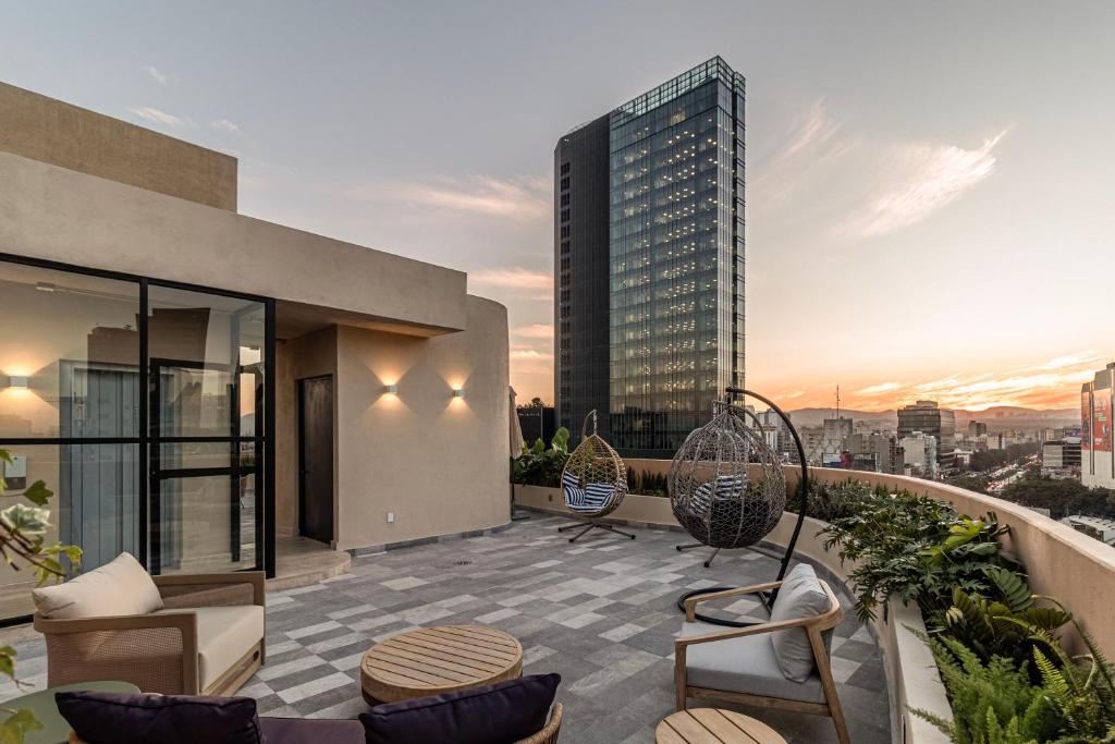 Un balcón de apartamento con sillas y vista a la ciudad. en Kukun Edition Marsella Juarez, en Ciudad de México