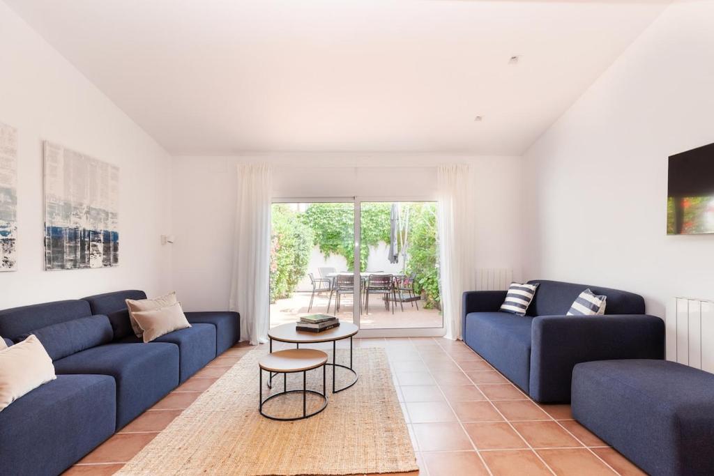a living room with blue couches and a table at Casa Rosari I - Jardín & Parking Privado in Vilassar de Mar