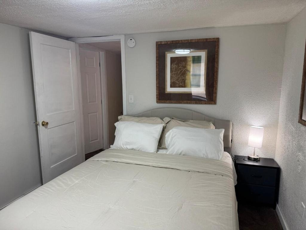 Cozy 3 4 BR Home Ideal for Family في كلاركسبورغ: غرفة نوم بسرير وملاءات بيضاء ومرآة