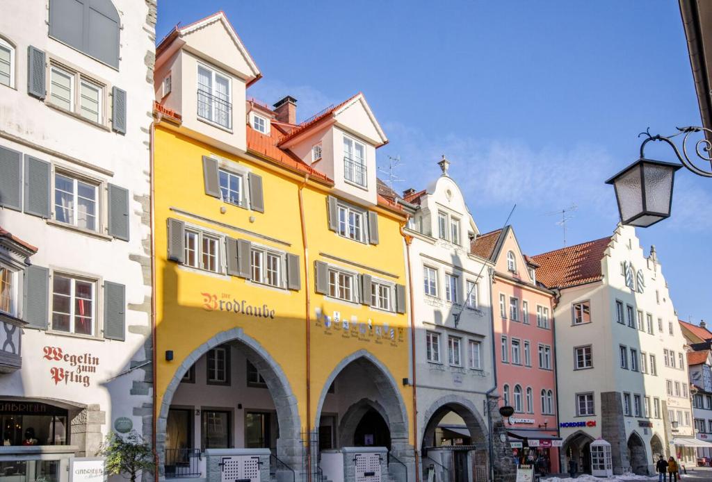 Maximilian Apartments Lindau في لينداو: مبنى اصفر وسط مجموعة مباني