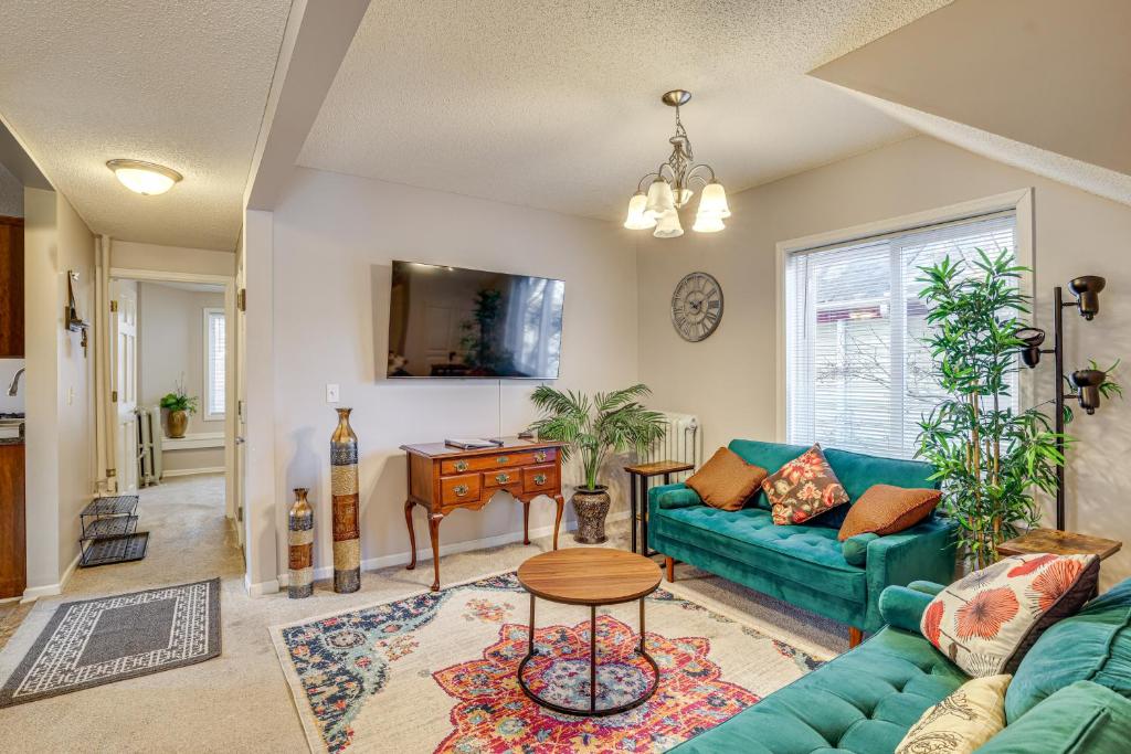 5 Mi to Dtwn St Paul Central Duplex Townhome في Falcon Heights: غرفة معيشة مع أريكة خضراء وطاولة