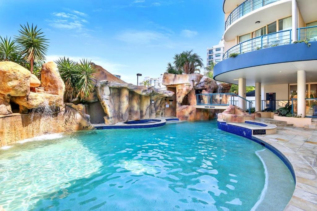 a pool in a resort with a water slide at Landmark 1 Bedroom Beachside Escape in Mooloolaba