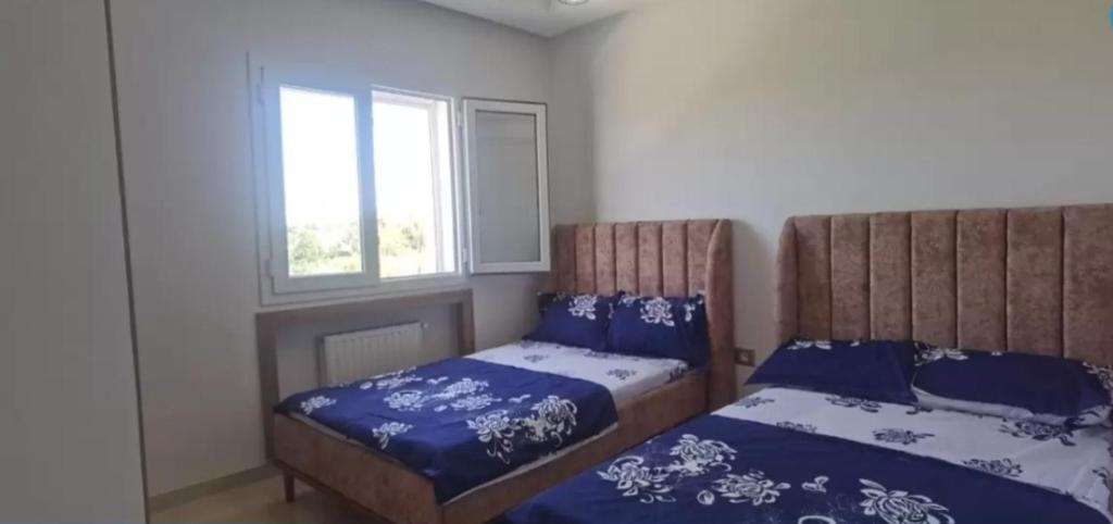 a bedroom with two beds and a window at Apartment222 2 rooms Al Bousten Hammamet in Hammamet Sud
