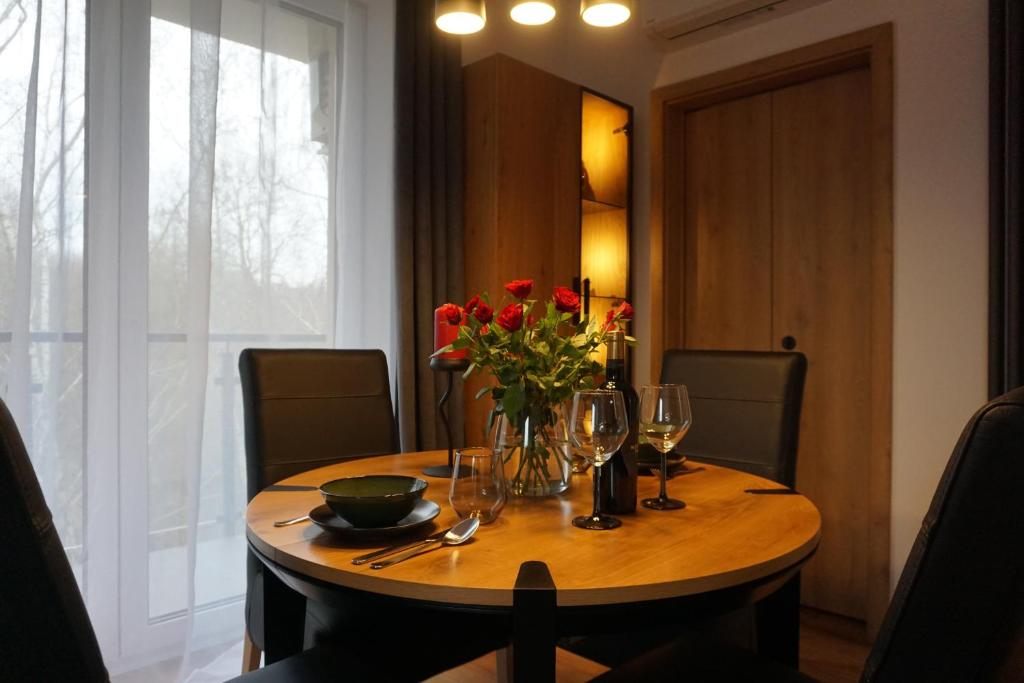 ヴィエリチカにあるVIP Apartments Victoriaの花瓶とワイングラスの木製テーブル