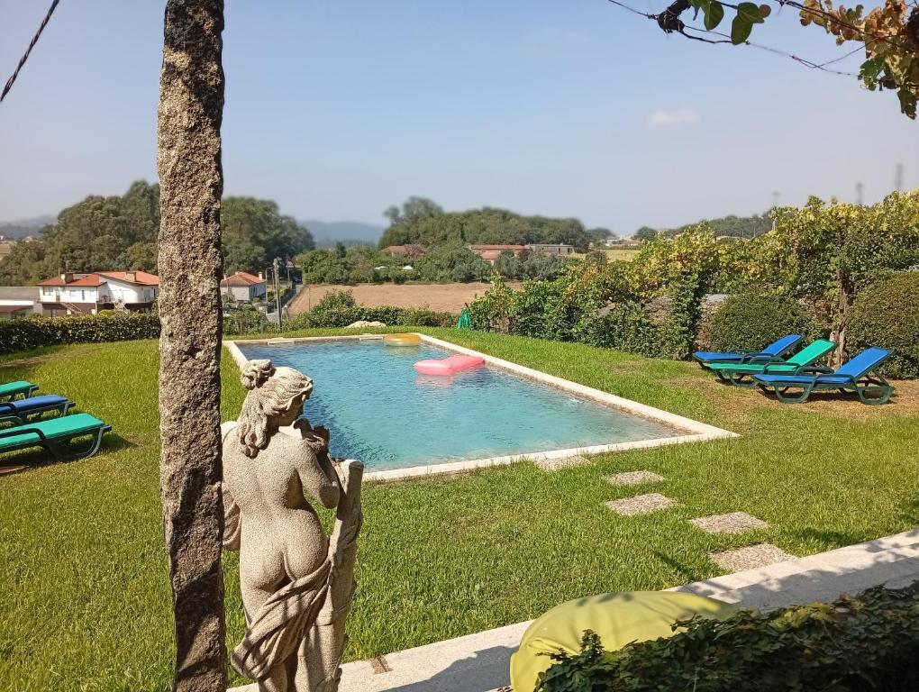 a statue of a woman standing next to a swimming pool at Casa com Piscina Privada de 10m e Jardim, até 8 pessoas, perto do Porto in Landim