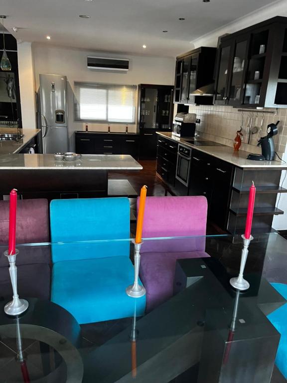 a kitchen with two colorful chairs and a glass table at Magnifique appartement villa in Martil