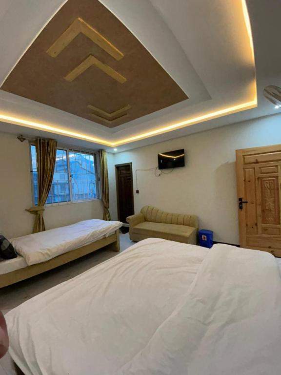 a bedroom with a large bed and a ceiling at Askari Lodges Murree in Murree