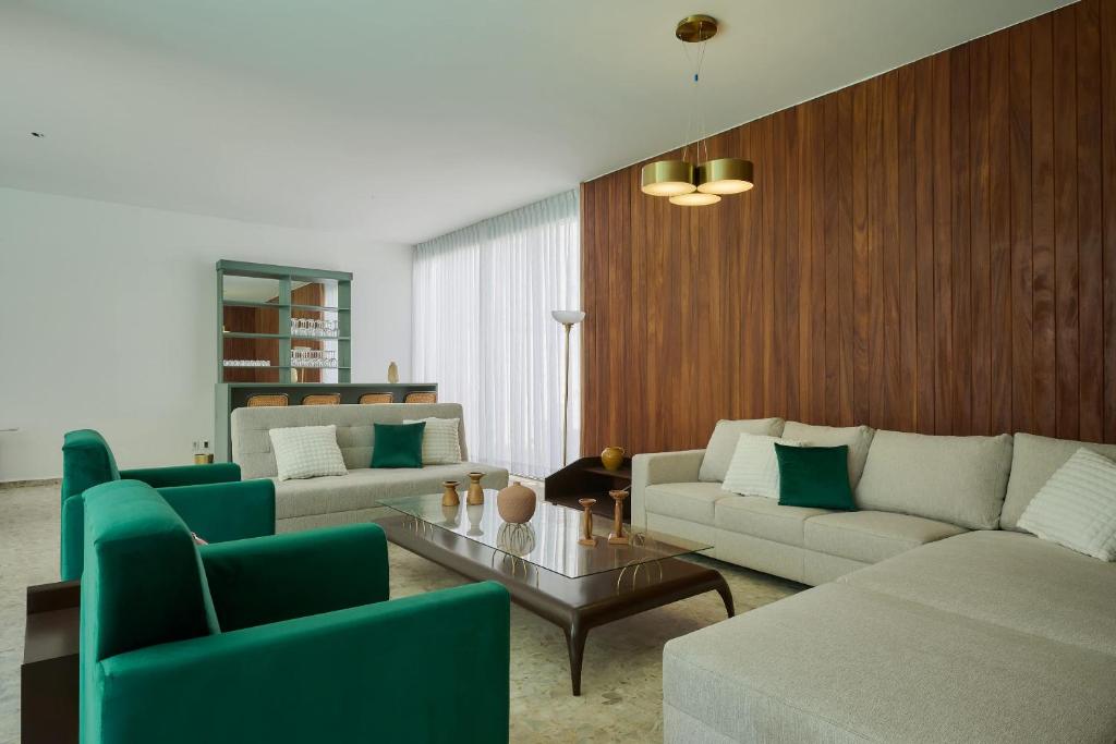 a living room with two couches and a table at Casa Orbit AC Pool Jacuzzi Central Location in Oaxaca City