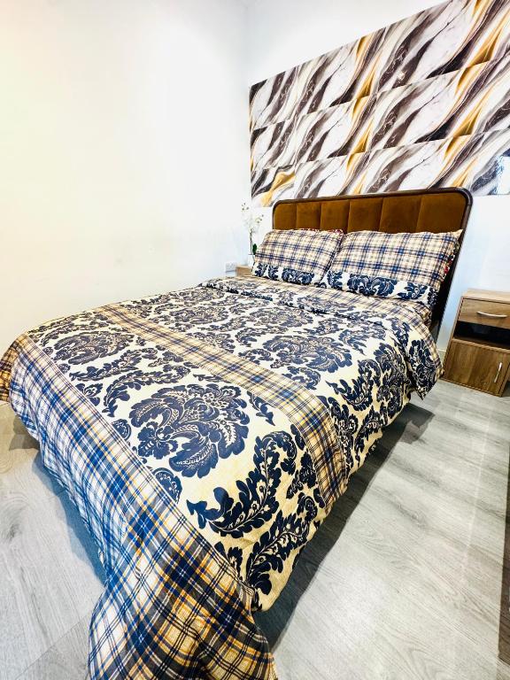 a bedroom with a bed with a blue and white blanket at Enjoy the comfort at private room en-suite with free Parking - near Luton airport in Luton