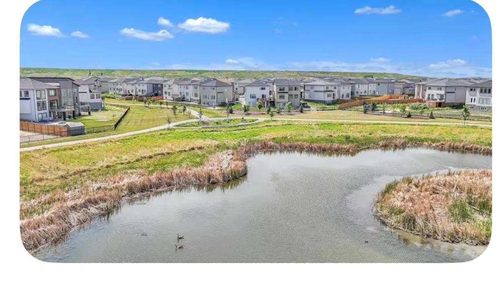 uma vista para um rio com casas ao fundo em Lakeview at Prairie Pointe em Winnipeg
