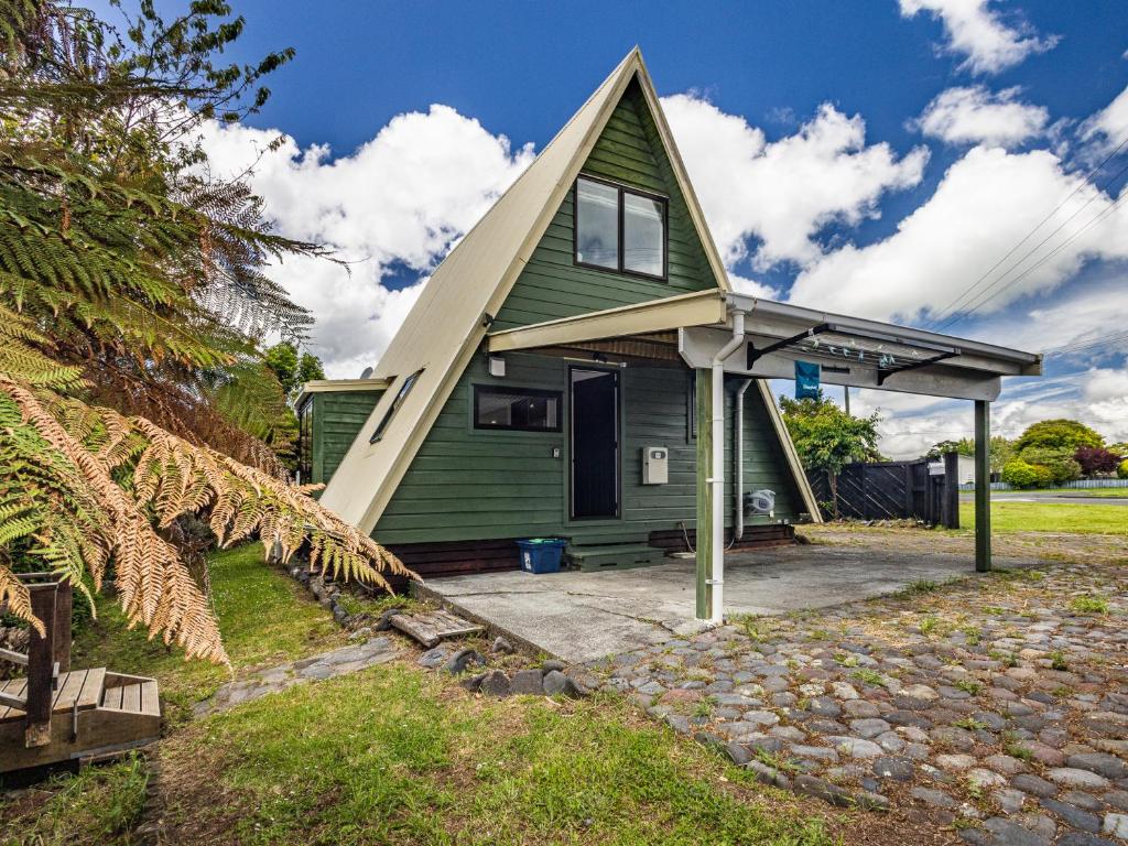 a green house with a gambrel roof at Peaks and Pines Chalet - Ohakune Holiday Home in Ohakune