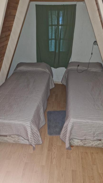 Cabañas Mateo في فيلا بيهوينيا: سريرين في خيمة مع أرضية خشبية