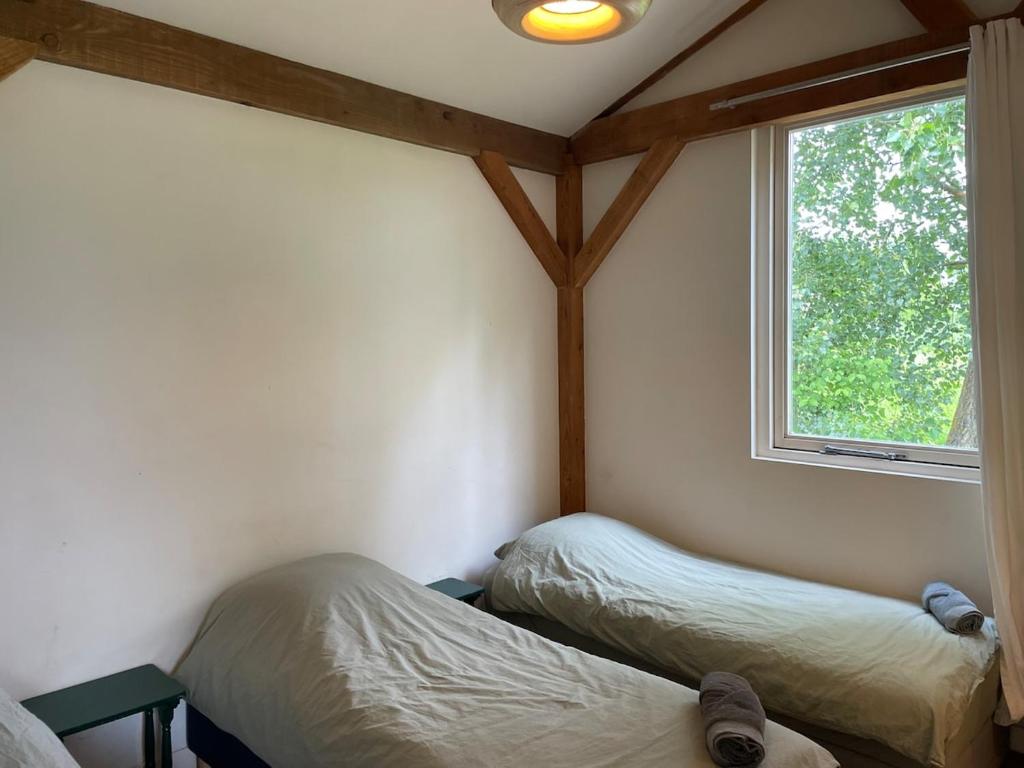 Un dormitorio con dos camas y una ventana. en Milan Farm Chalet cozy, en Milán