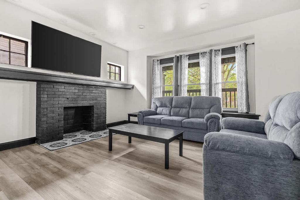 a living room with two couches and a fireplace at Charming 4BR Niagara Apartment Great Location in Niagara Falls