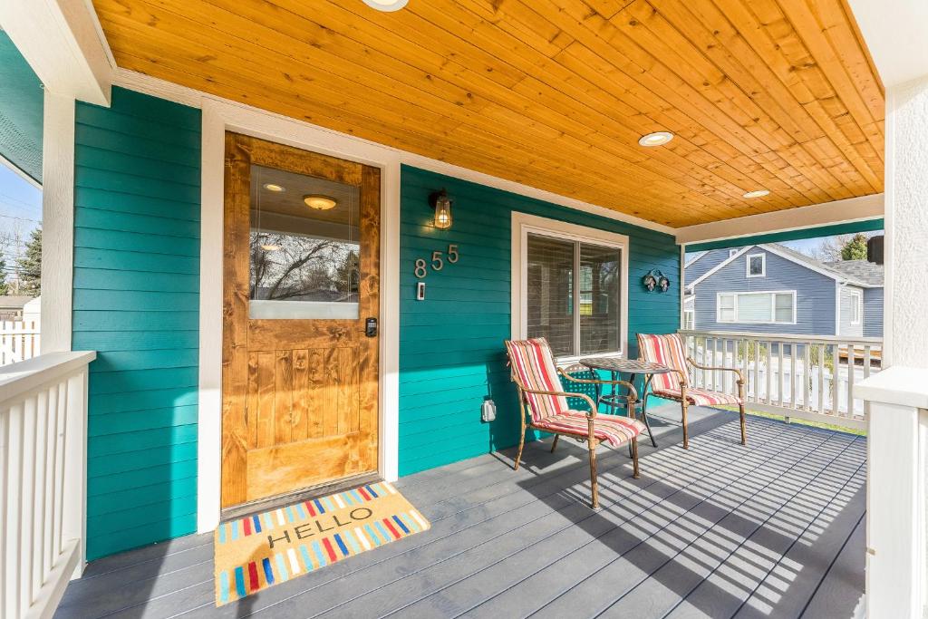 a blue house with a wooden door and chairs on a porch at 855 N Grant Ave in Loveland