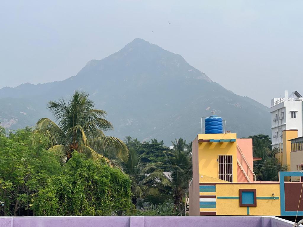 a yellow building with a mountain in the background at Love Home stay in Dharmpura