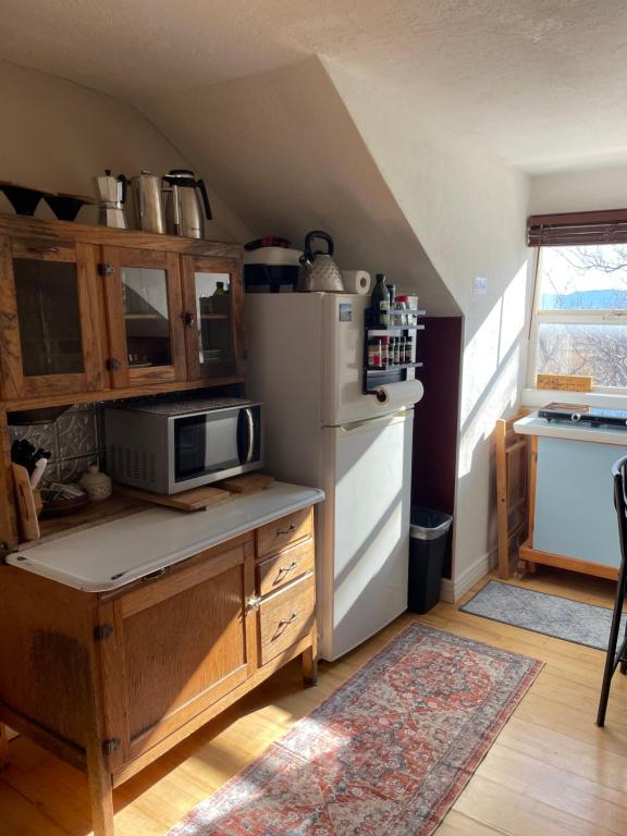 een keuken met een koelkast en een tafel met een magnetron bij The Desert Farm in Escalante