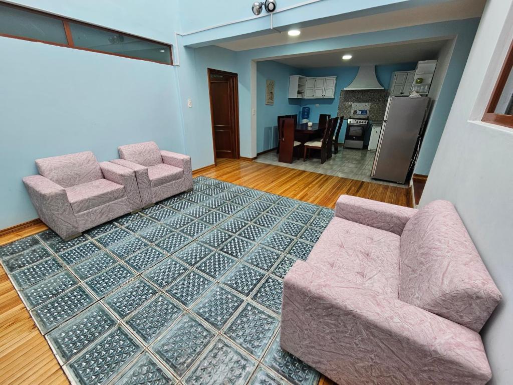 a living room with two chairs and a rug at Hospedaje Familiar Ecuador in Cuenca