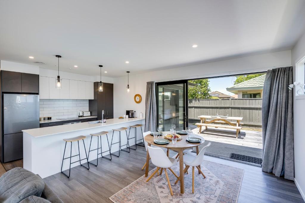 a kitchen and living room with a table and chairs at Quiet on Cassin - Taradale in Napier