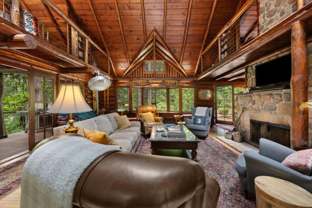 a living room with a couch and a fireplace at Lookout Log Cabin in Rhododendron